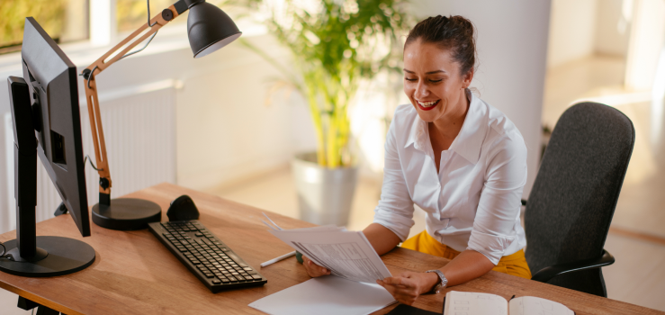 Woman at Desk Looking at Paperwork