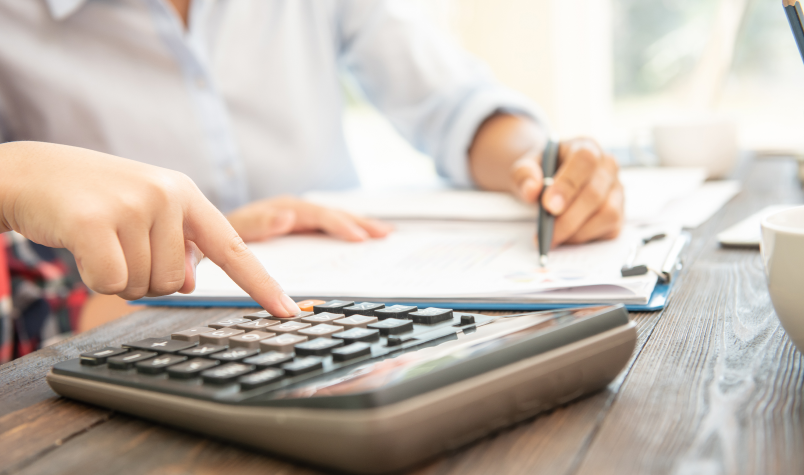 Two people at a desk Using a Calculator