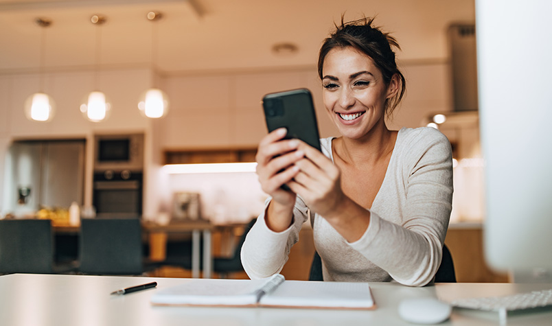 Woman on cellphone at kitchen table