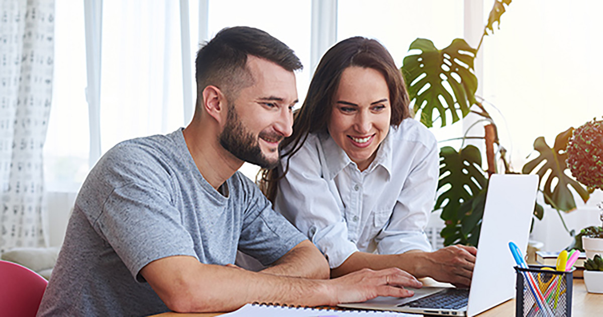 Husband and wife looking at computer to optimize bank accounts