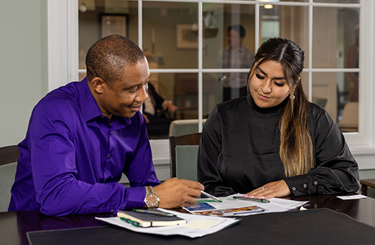 Man & woman looking at financial papers on desk