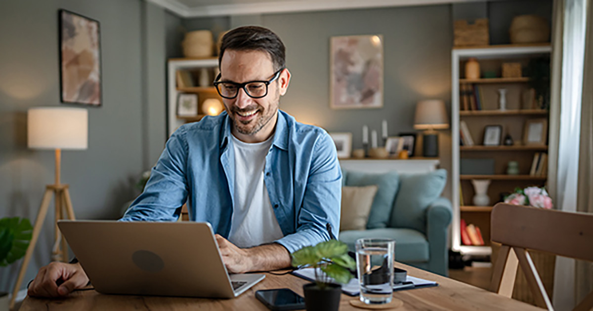 Man at kitchen table on laptop
