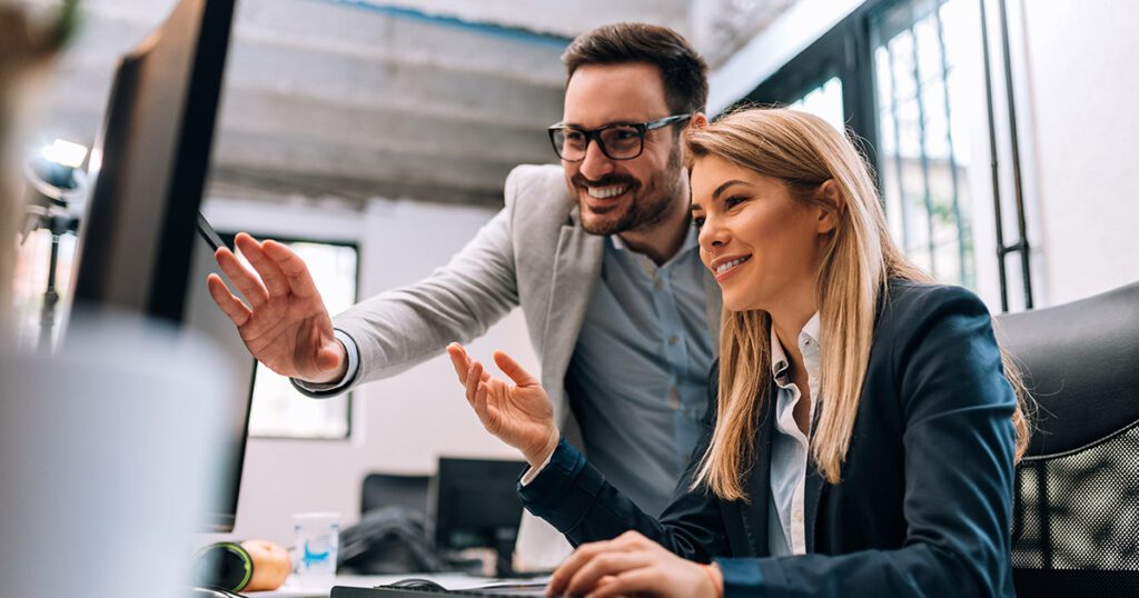 Business man and woman on pointing at computer