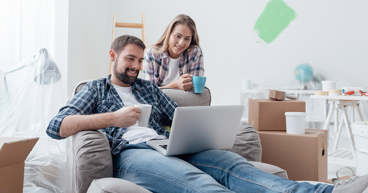 Young couple in their home looking at a laptop