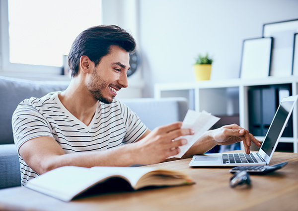 Man paying off bills on laptop