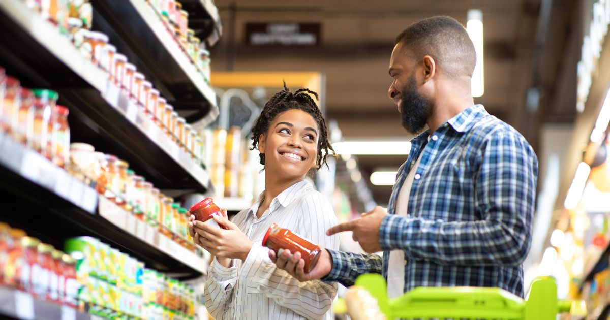 Couple smiling at each other while shopping a grocery store
