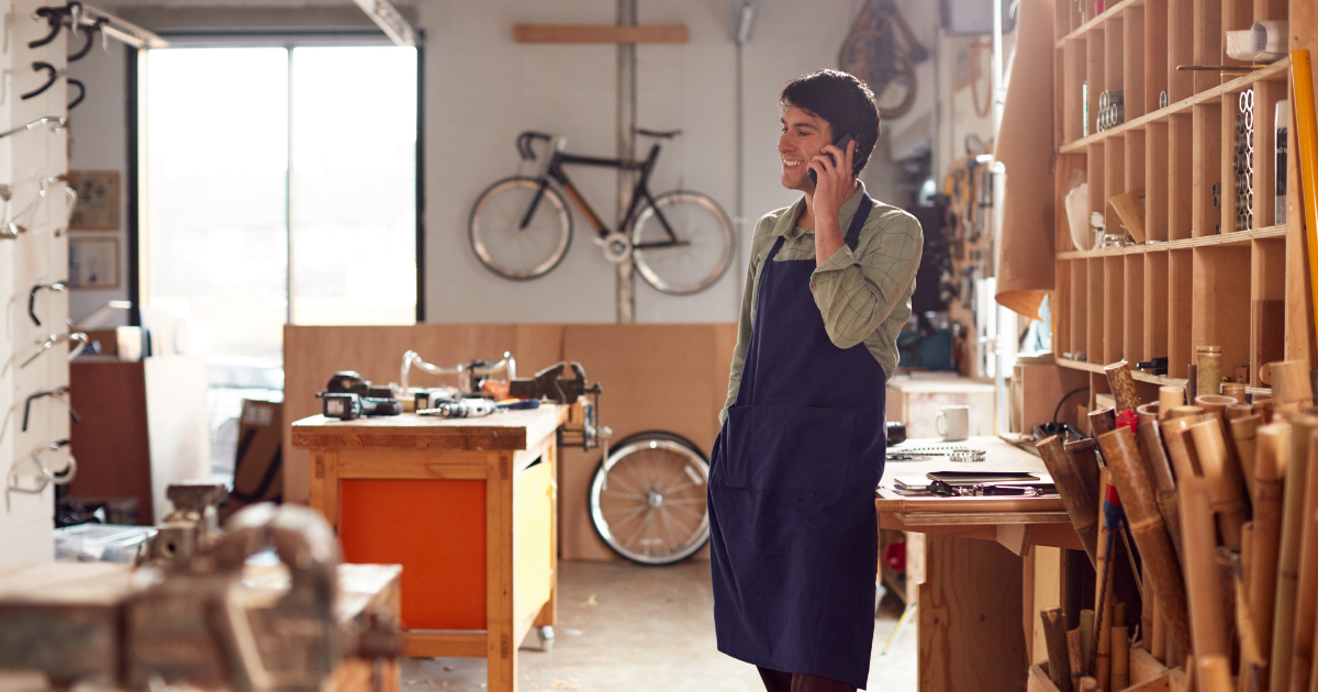 Man talking on phone in bike workshop.