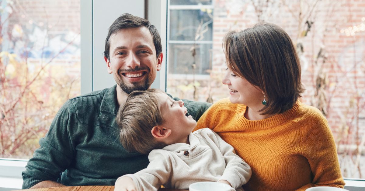 Woman and man couple smiling with toddler.