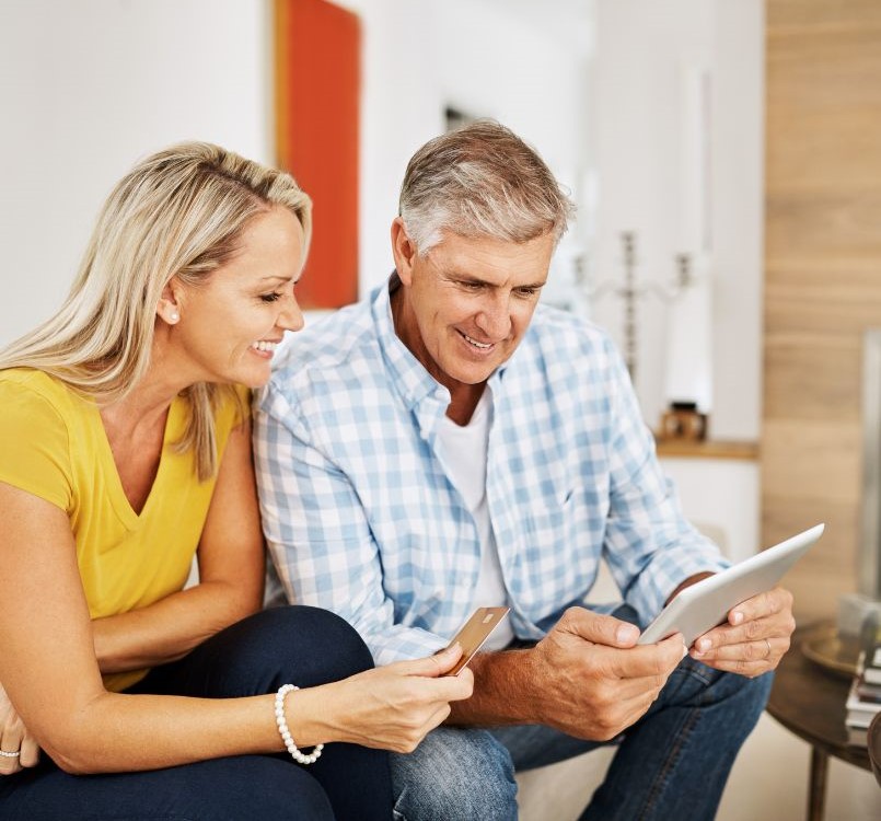 Middle aged couple with tablet and card