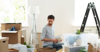 Young man unpacking boxes in his new apartment.