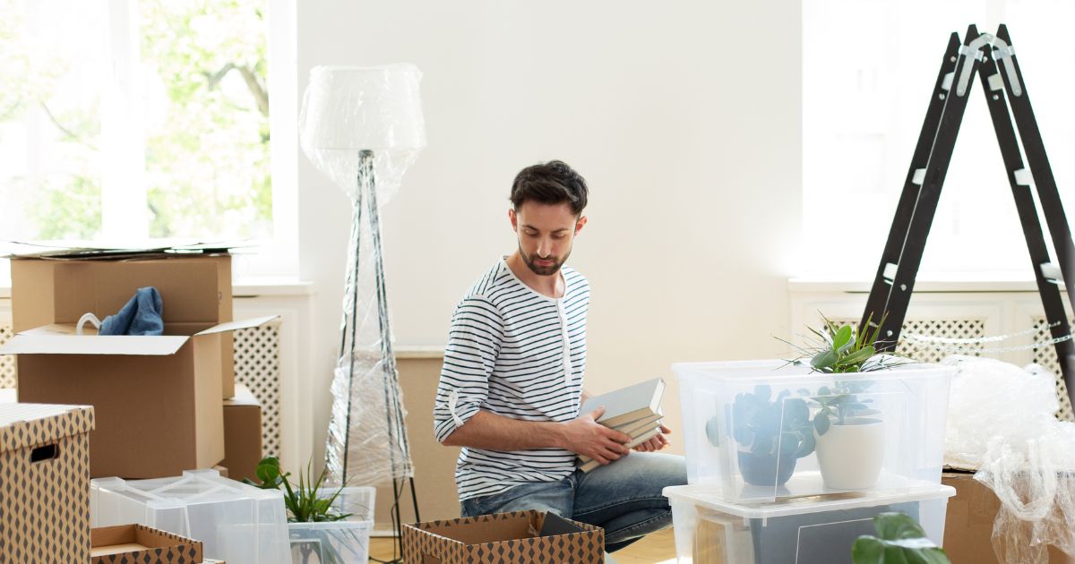 Young man unpacking boxes in his new apartment.